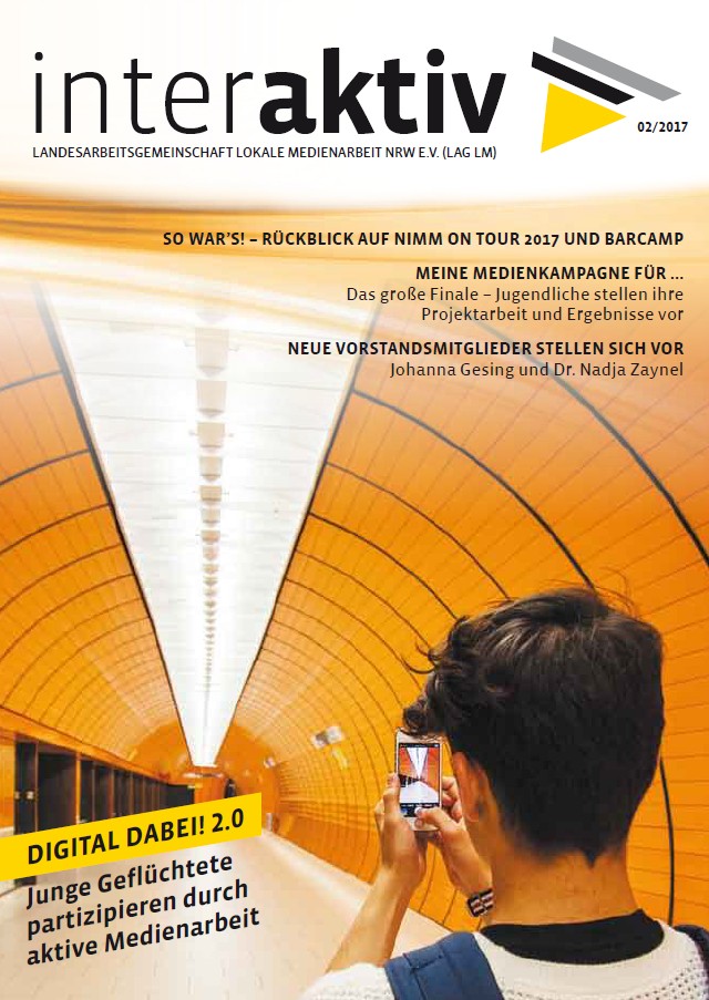 Ein Jugendlicher filmt mit Smartphone eine orange beleuchtete Tunnelinnenwand mit weißen Leuchten