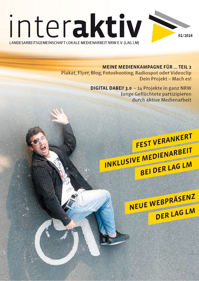 Ein junger Mann mit Sonnenbrille und Jacke sitzt auf Boden mit Rollstuhlsymbol