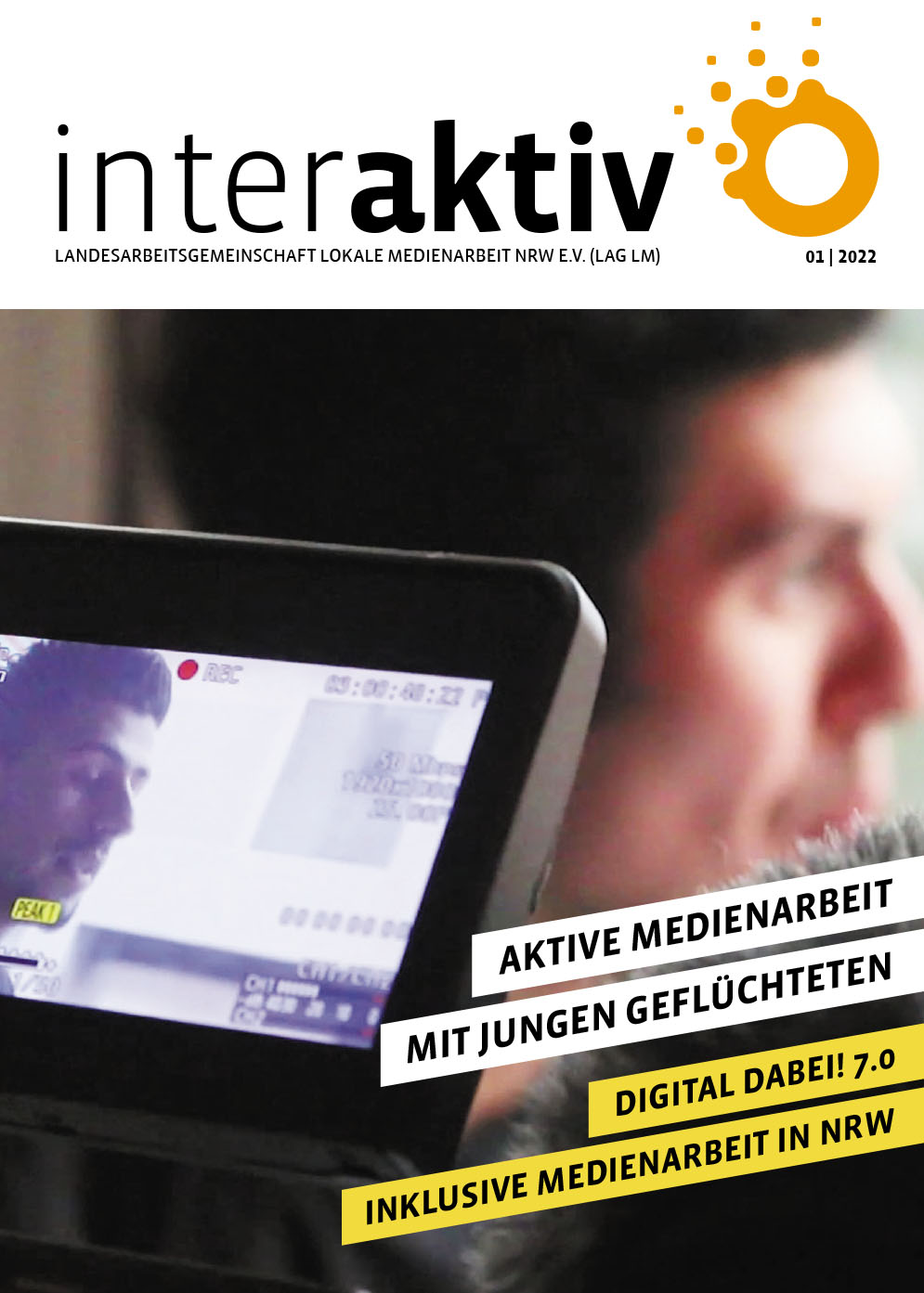 Man sieht den Bildschirm einer Kamera, die gerade einen Jugendlichen in einem Interview filmt. Im Hintergrund sieht man das Gesicht des Jugendlichen unscharf.