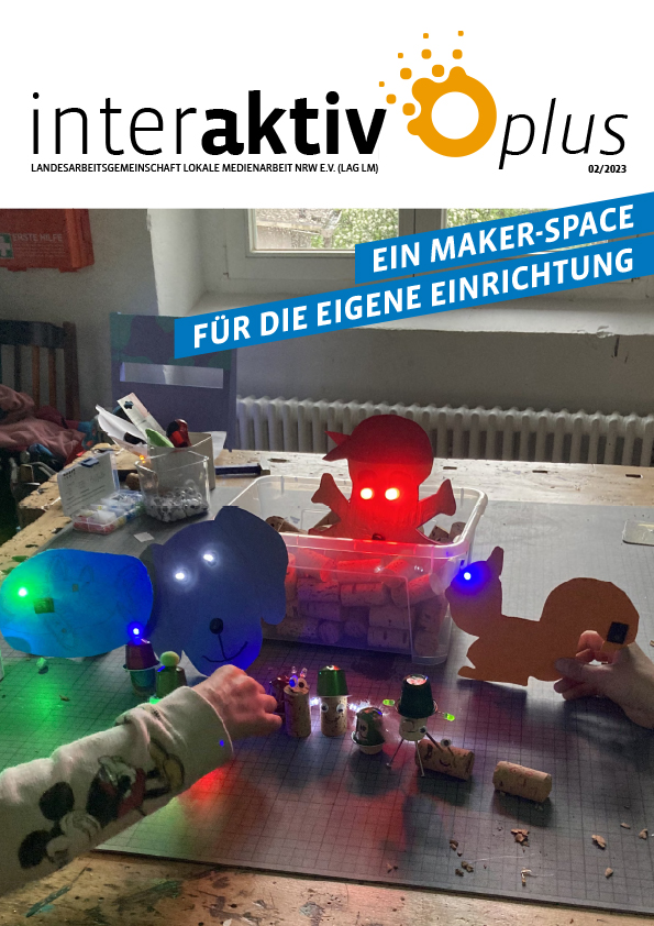 Kinderhände bedienen leuchtende, bunte Maker-Space-Objekte auf einem Tisch in einem hellen Raum mit Fenster und Heizung