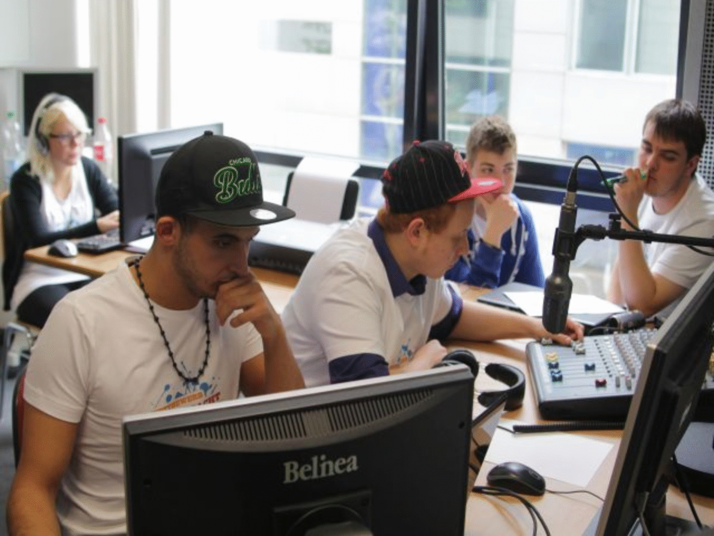 Jugendliche sitzen an PC-Monitoren