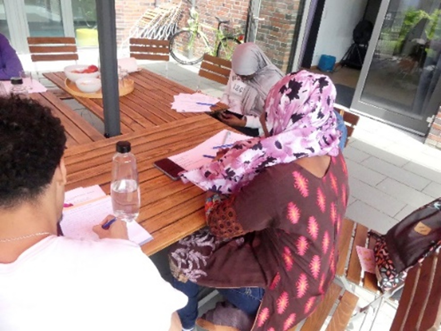 2 Mädchen mit Kopftuch sitzen an einem Tisch und bereiten eine Podcast Aufnahme vor