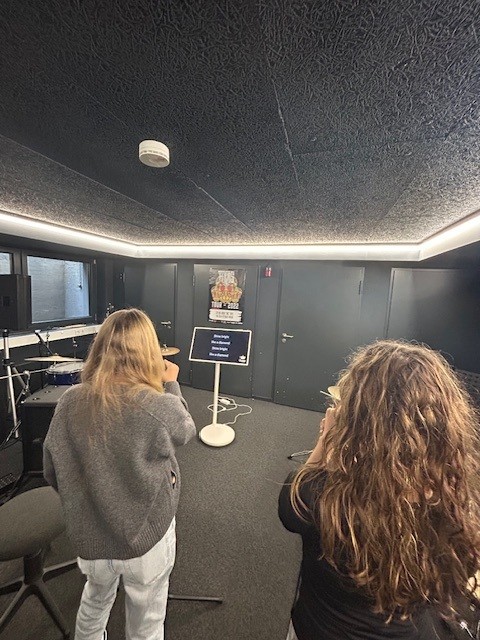 Jugendliche stehen in einem Aufnahmestudio und singen