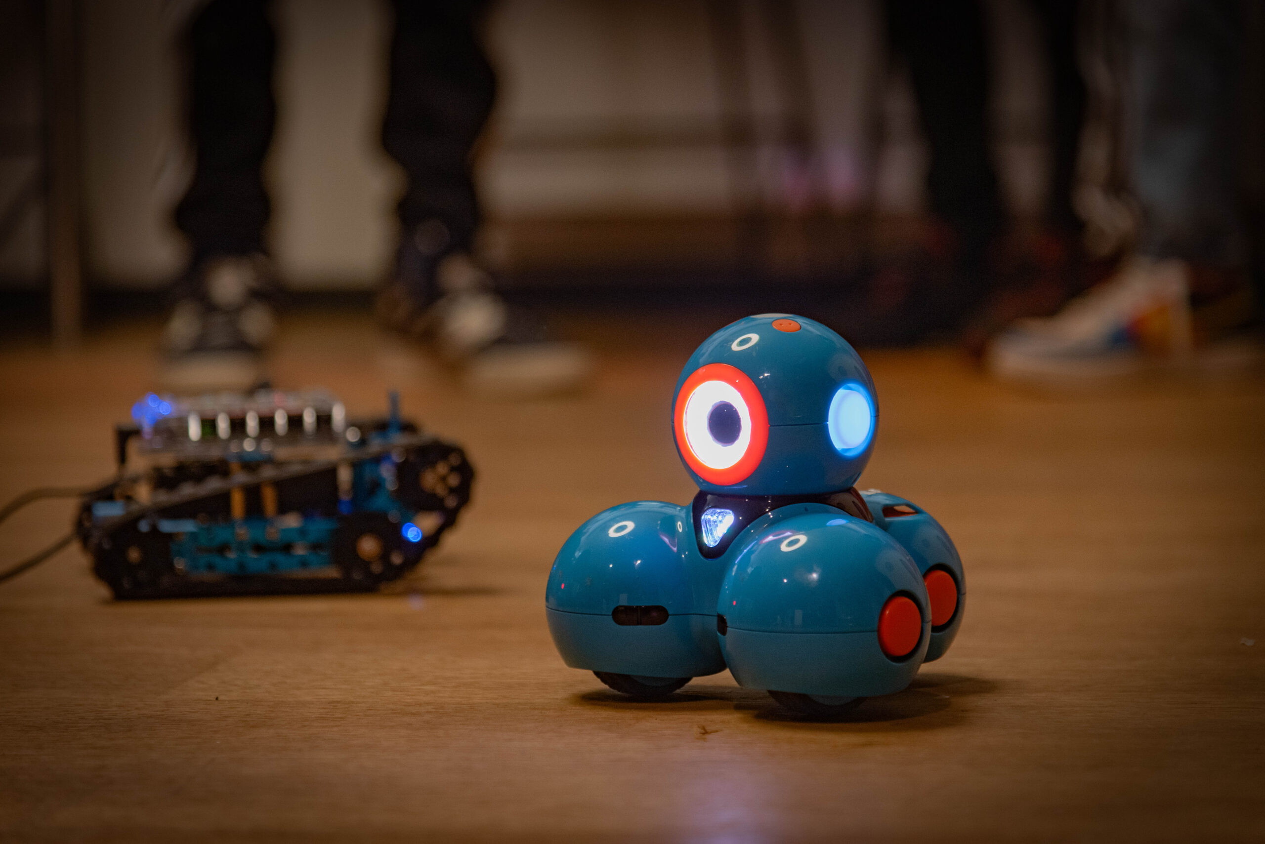 Ein mBot und ein Dashbot fahren auf dem Boden