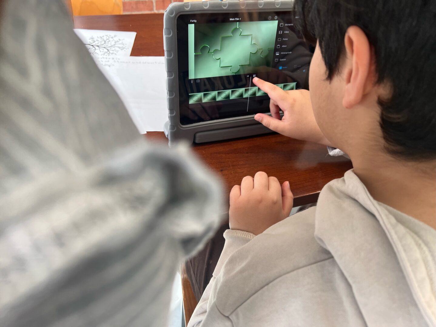 Ein Kind bedient auf einem Tablet ein Filmschnitt-Programm