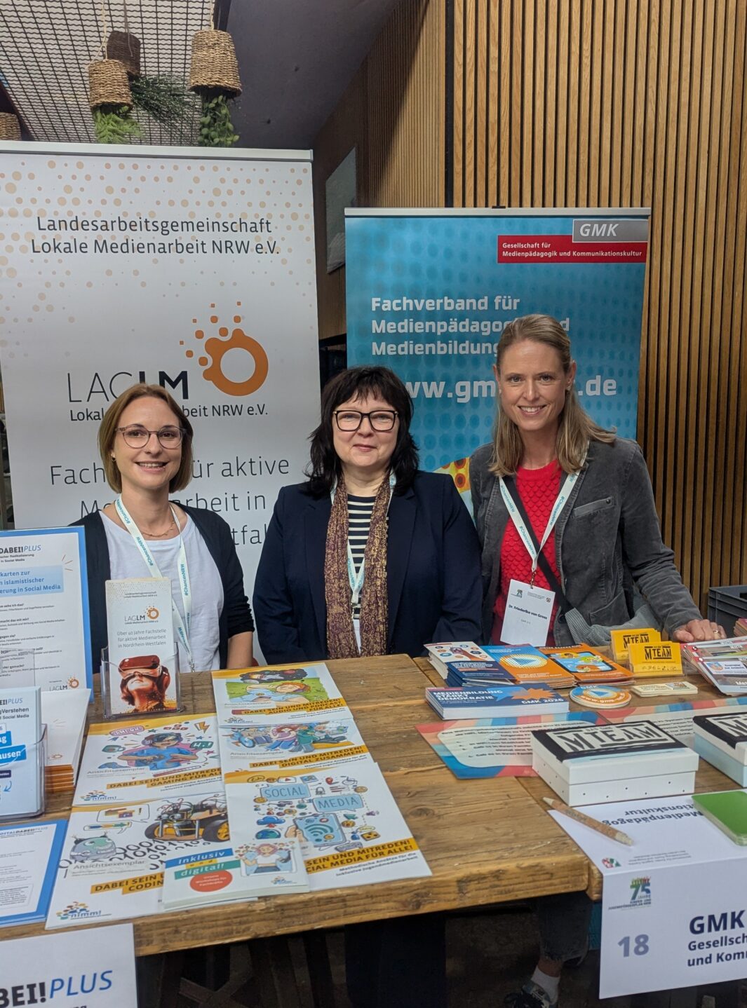 Dr. Christine Ketzer und Michelle Krüger von der LAG Lokale Medienarbeit NRW e.V. und Friederike von Gross von der GMK am Stand beim 75-jährigen Jubiläum des KJFP