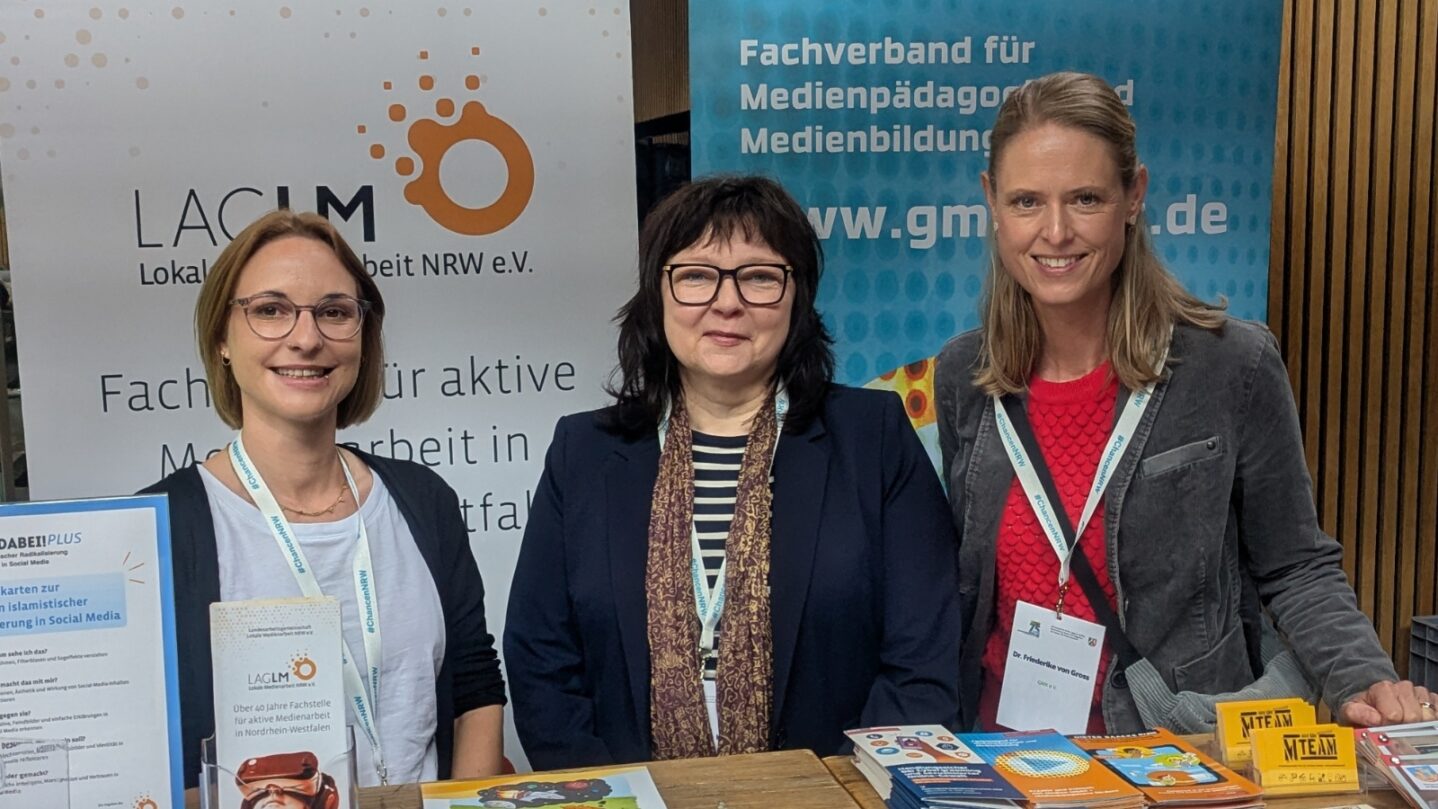 Dr. Christine Ketzer und Michelle Krüger von der LAG Lokale Medienarbeit NRW e.V. und Friederike von Gross von der GMK am Stand beim 75-jährigen Jubiläum des KJFP