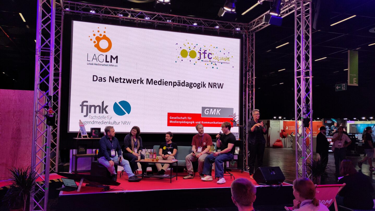 Das Netzwerk Medienpädagogik NRW (LAG Lokale Medienarbeit NRW e.V., GMK, fjmk und jfc Medienzentrum e.V.) im Gespräch auf der Bühne beim Jugendforum NRW 2026