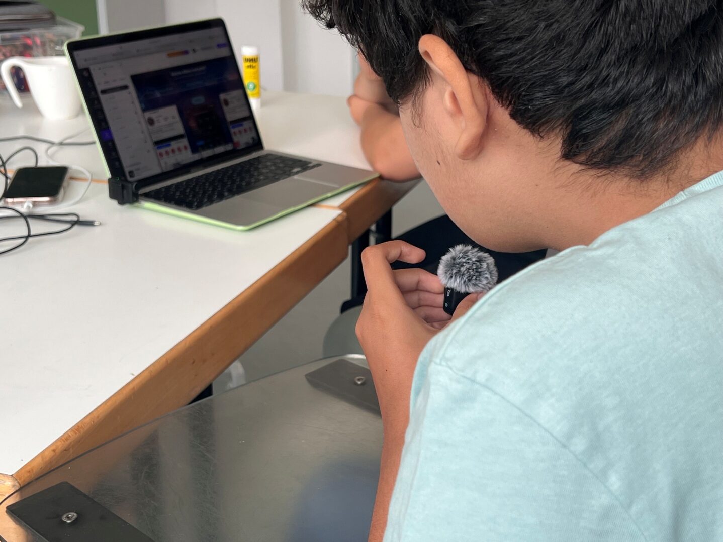 Jugendliche nehmen eine Nachricht auf und bearbeiten sie dann an einem Laptop